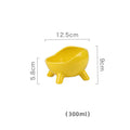 Green ceramic cat food bowl with four legs, wide mouth, and rounded arc shape on a light floor