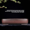 Handmade antique rectangular purple clay flower pot for plants on a tabletop.
