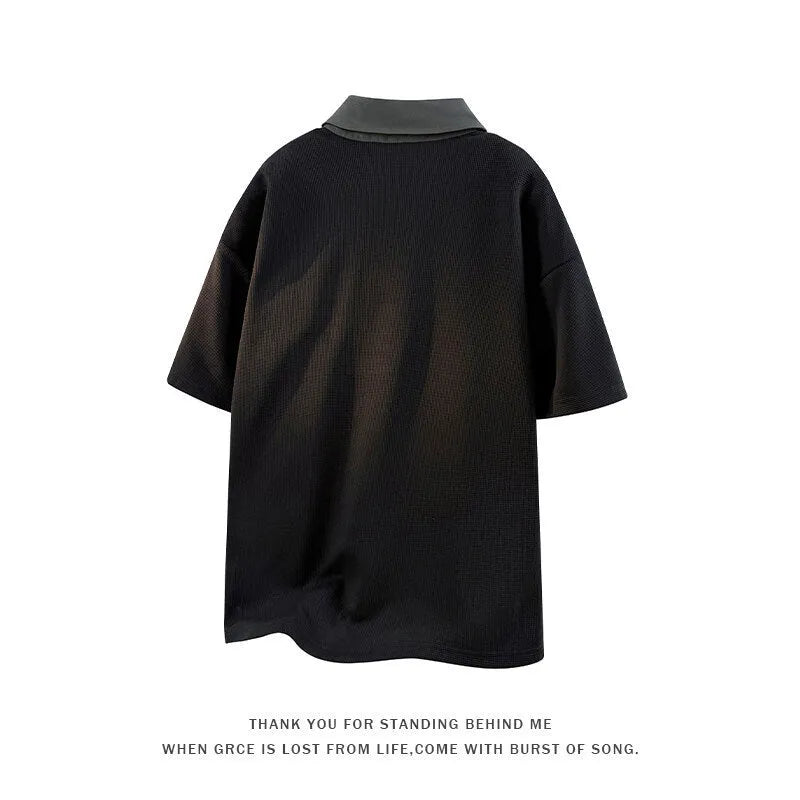Man wearing a black heavy Henry collar short sleeve polo sweater with padding.
