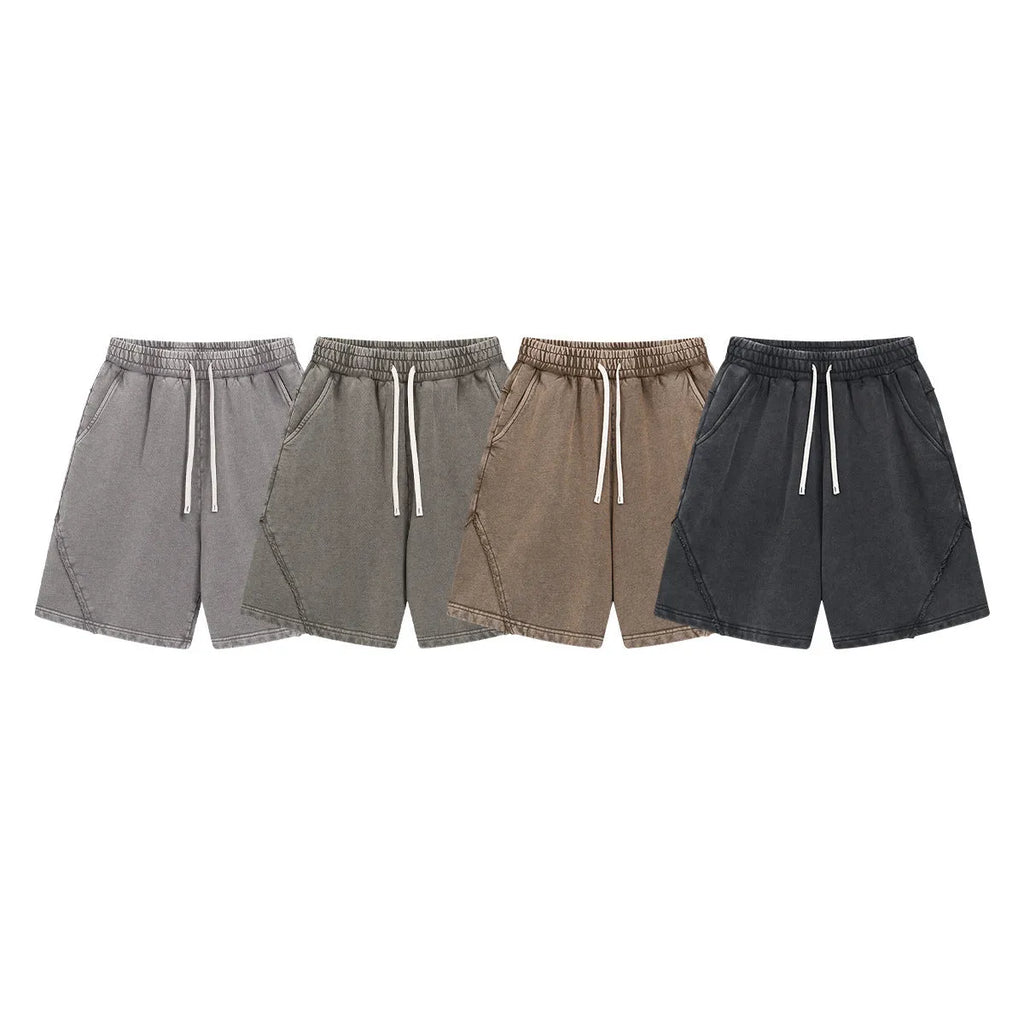 Man's loose-fit cotton terry shorts in a batik wash colour with a craft patch detail, shown in a street fashion style.
