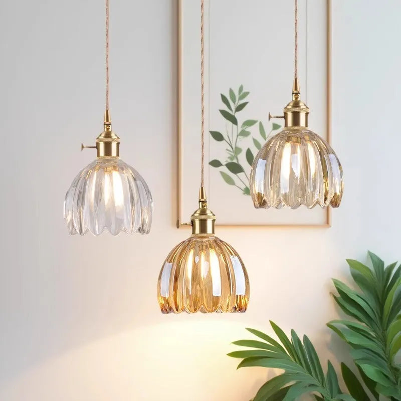 Nordic style bedside chandelier with a glass flower shade in amber, on a white background.