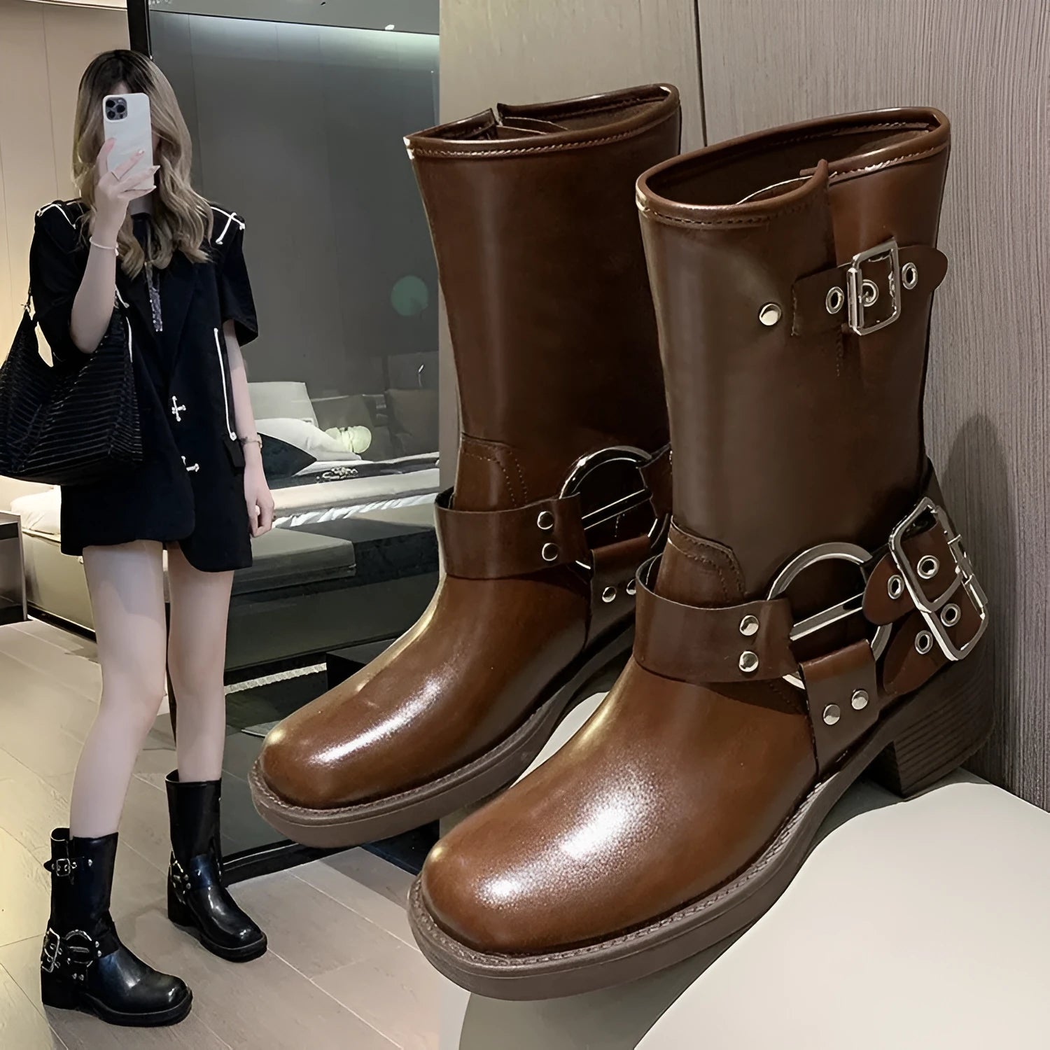 Women's black platform boots with belt buckle decoration showing mid-calf height