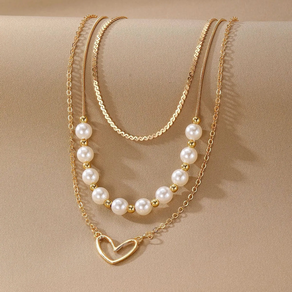 Vintage love heart pearl gold necklace with electroplated alloy pendant and adjustable pearl chain on a white background