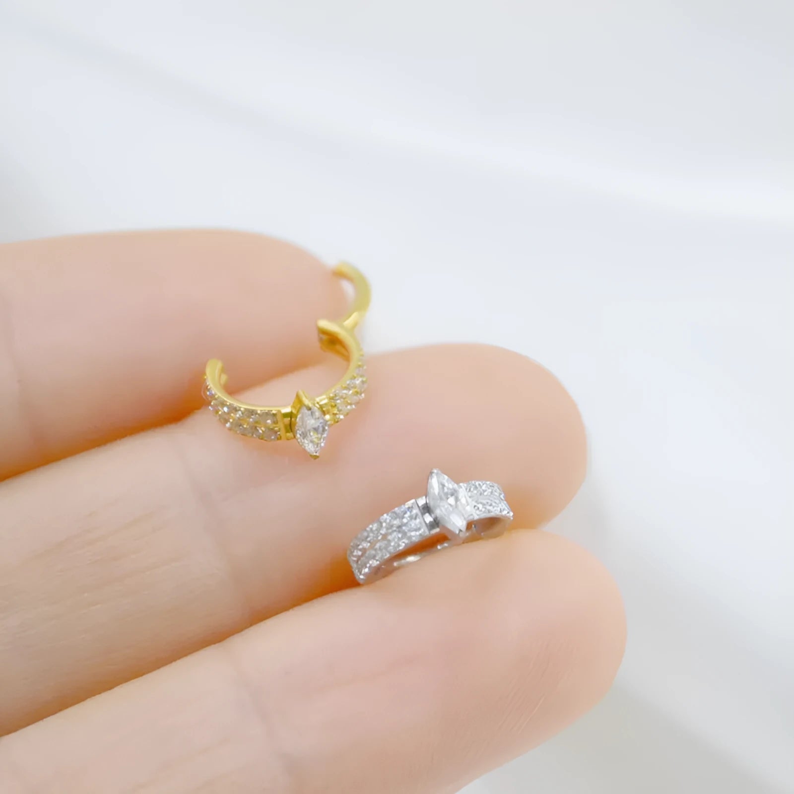 Close-up of a heart-shaped zirconia earring on a 316L steel post in silver tone.