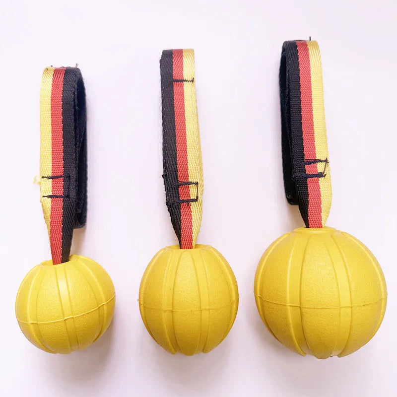 A floating EVA foam dog tetherball with a string attached, shown in camouflage colour next to a yellow one.