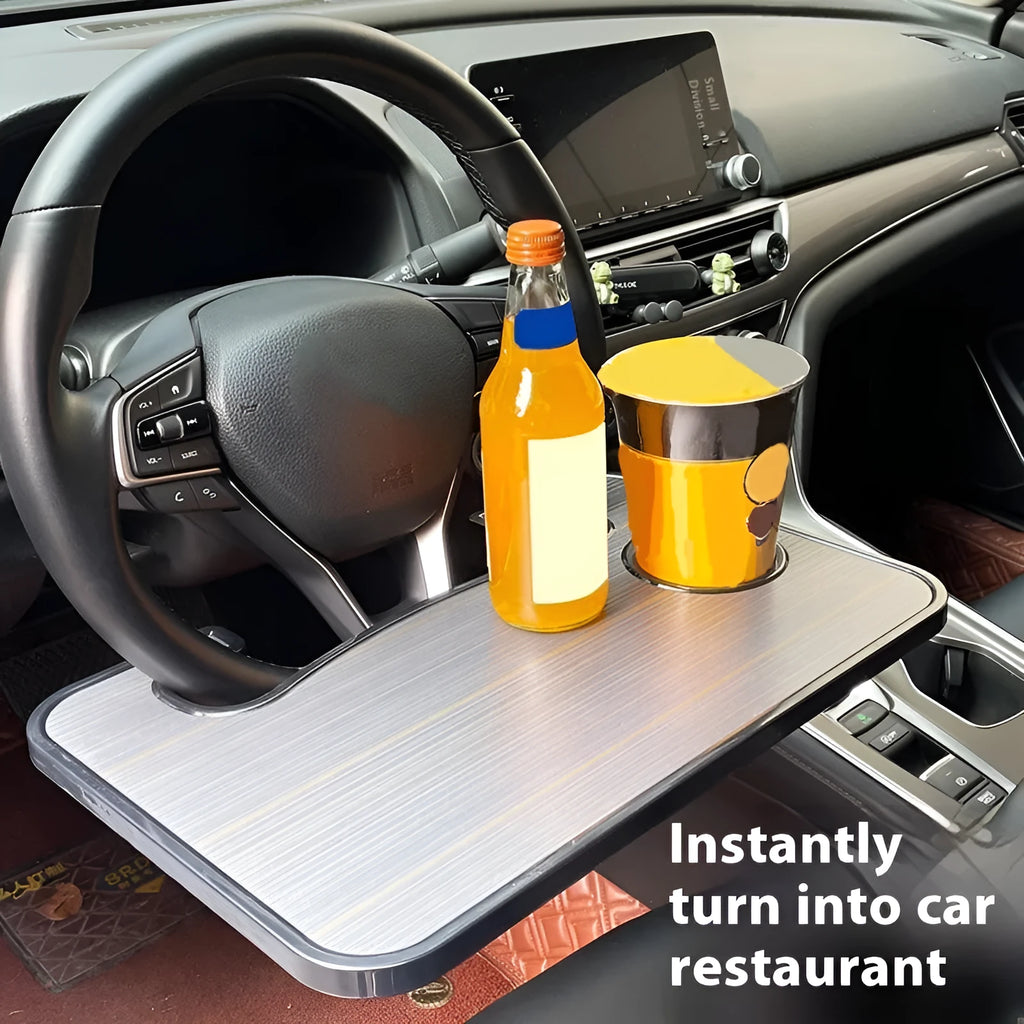 Black car steering wheel laptop tray mounted on vehicle steering wheel with laptop placed on surface