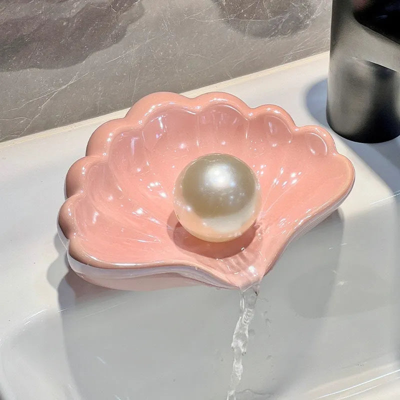 Pearl white plastic shell-shaped soap dish with drainage channels measuring 12cm long