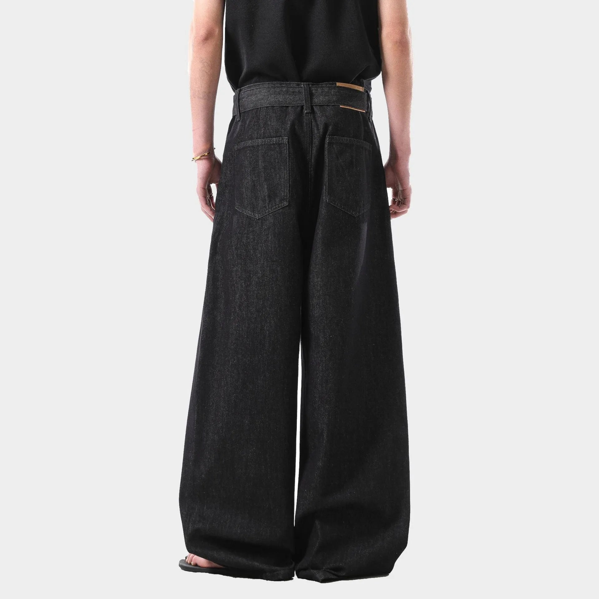 Black high-waist straight-leg jeans with a retro gold wash detail on a mannequin.