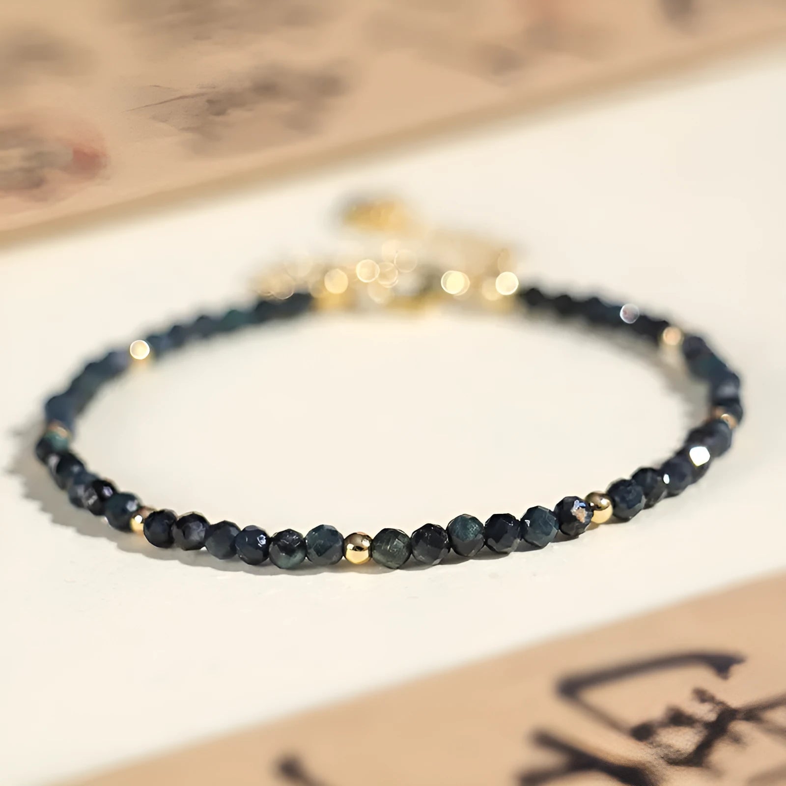 Close-up of a blue tourmaline bracelet with 3mm cut beads and spacer beads.