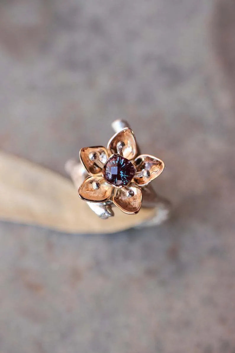 Silver two-tone women's ring with a geometric floral design on a finger.