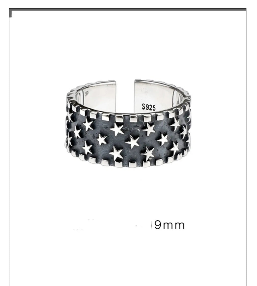 Adjustable sterling silver ring with a raised five-pointed star design on the band.