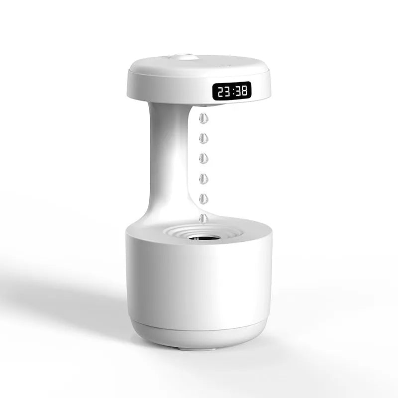 White anti-gravity air humidifier with ultrasonic mist levitating water drops on a desk