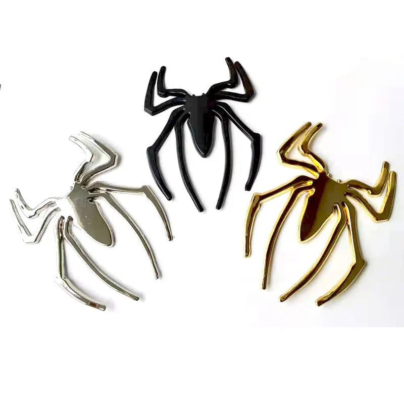 Three-dimensional metal spider bumper sticker in silver finish, measuring 7cm by 5cm.