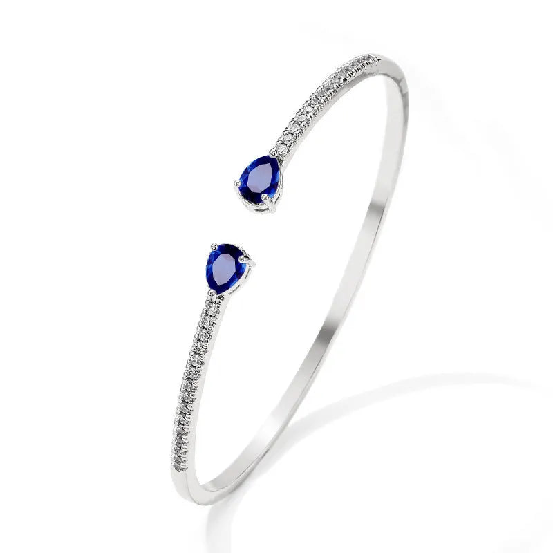 Copper bracelet with inlaid zircon detailing in simple style, shown in white and blue colour options.