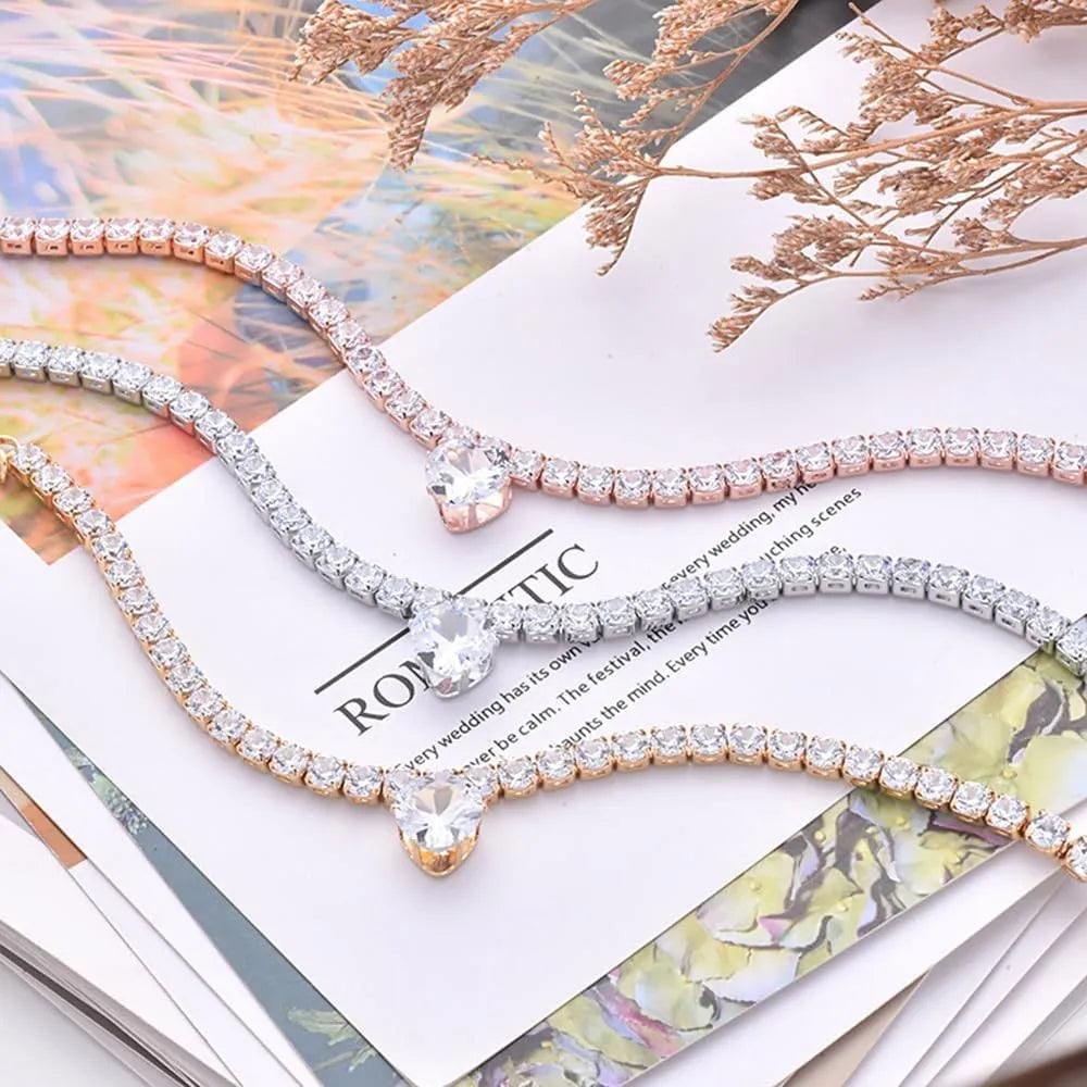 Gold rhinestone heart-shaped decorative collar for a cat or dog on a white background.