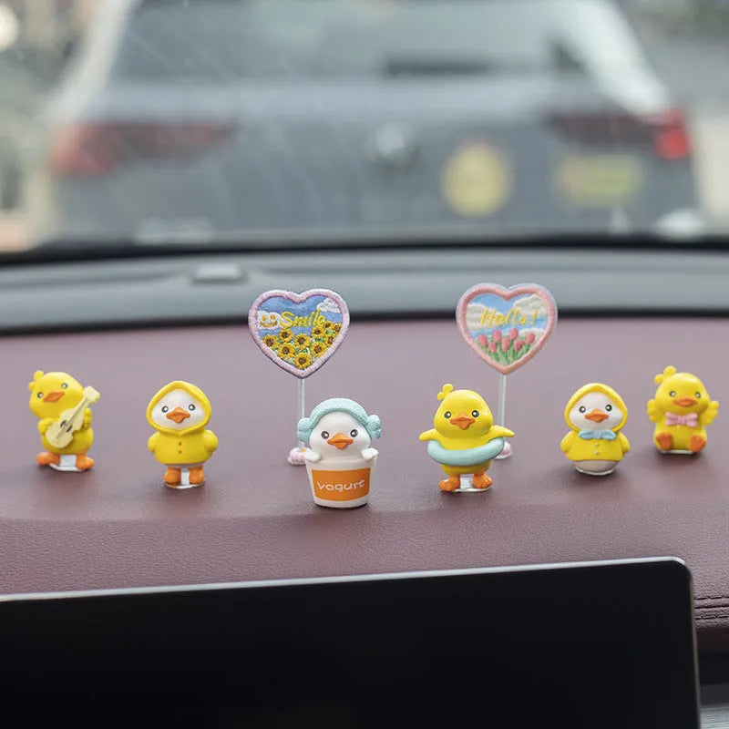 Set of six small yellow PVC duck figurines and one Hello sign for car dashboard decoration.