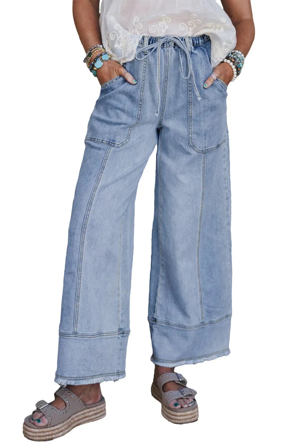 Beau Blue colour wide leg denim trousers with a drawstring waist and raw hem seam detail laid flat.