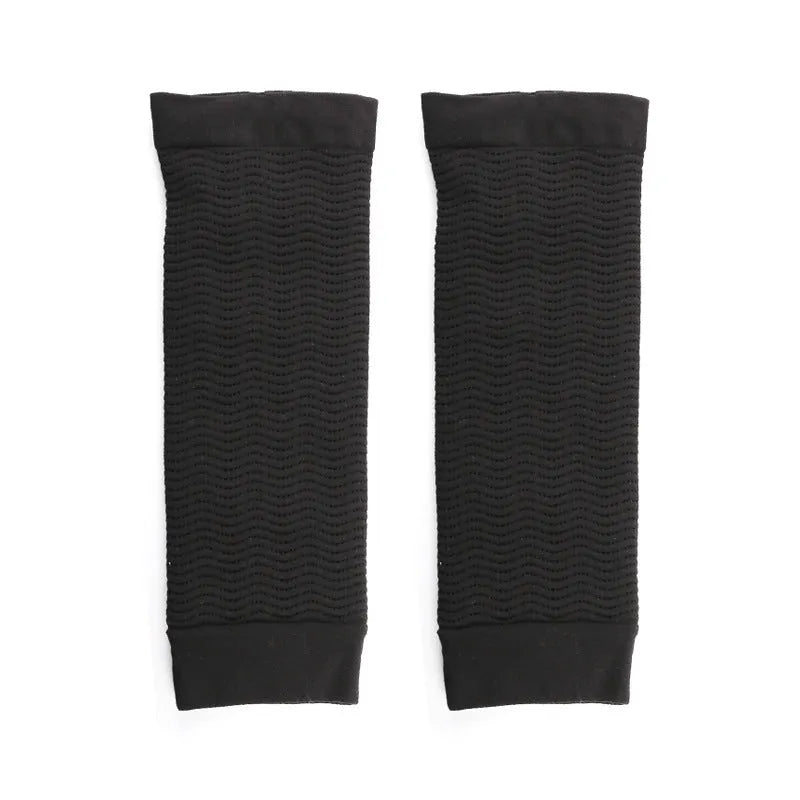 A pair of women's solid colour shaping arm sleeves in nylon fabric, shown in black and skin colour options.