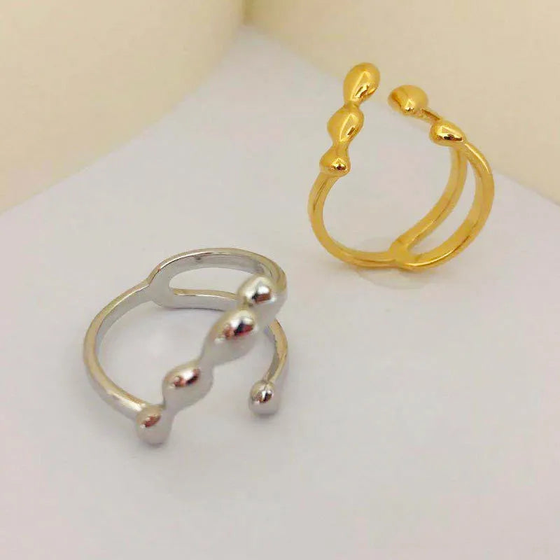 Brass opening ring with spherical element in gold finish on model finger