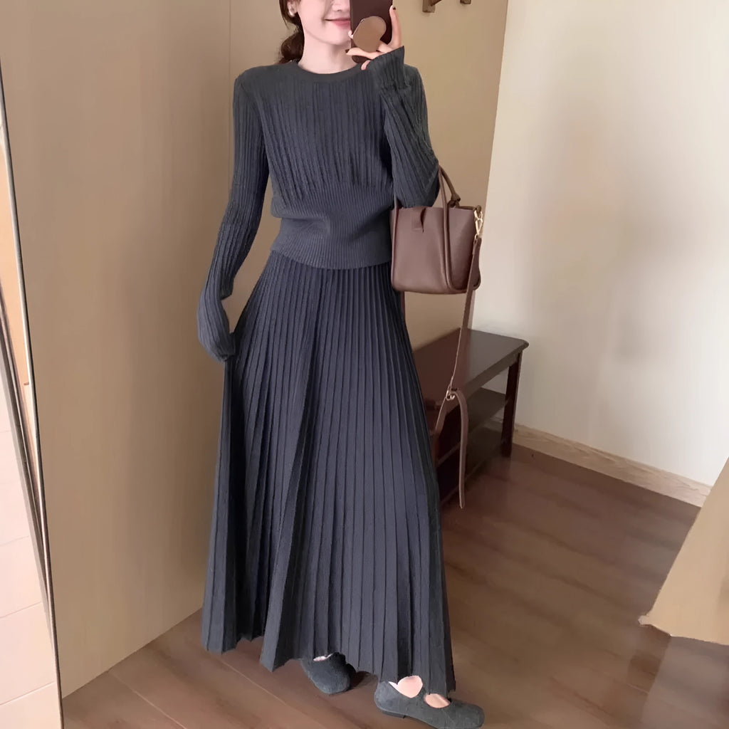 Women's dark grey knitted dress suit set with sweater and skirt showing 3D knit pattern and collage stitching