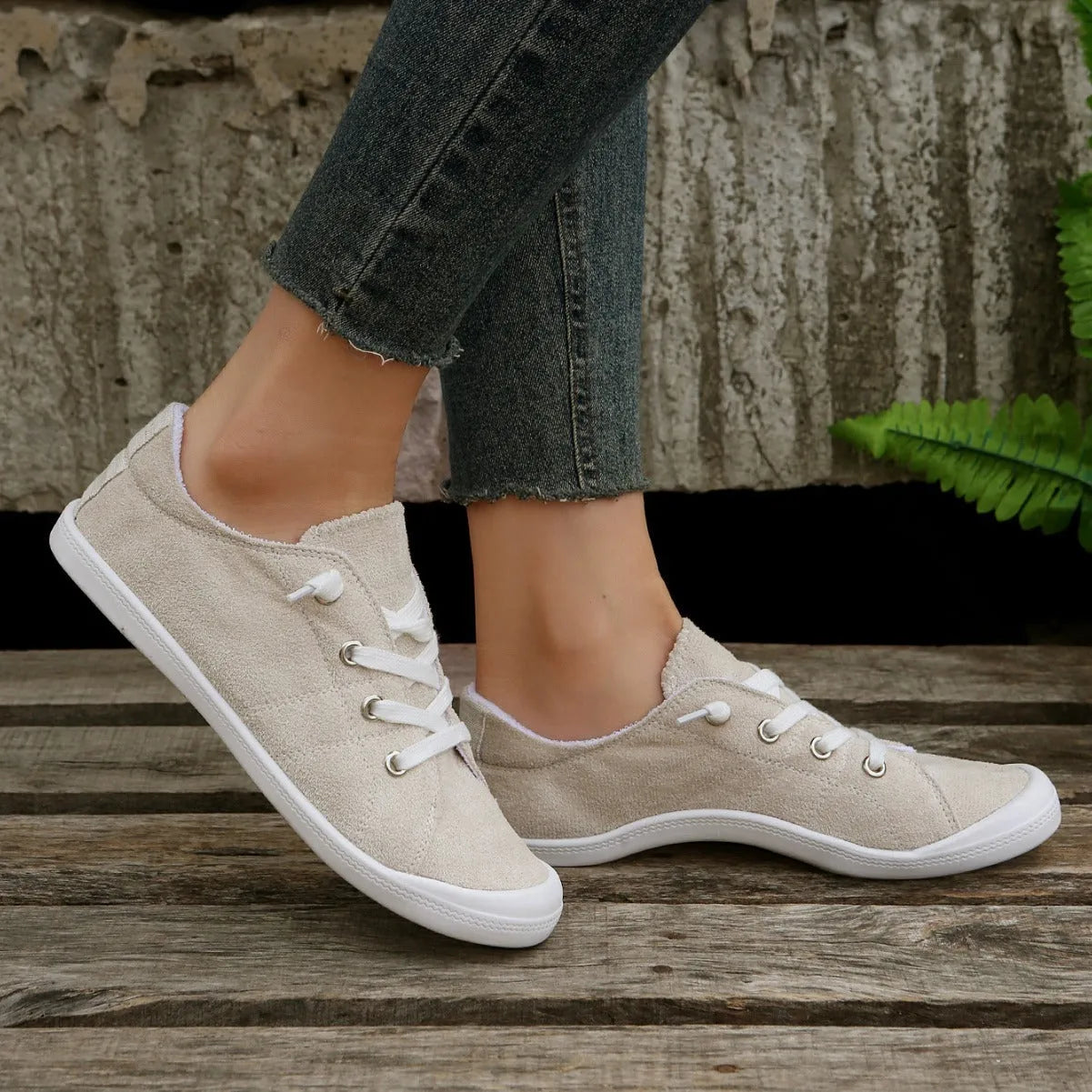 Women's creamy white casual low-top sneaker with soft fabric upper and rubber sole.