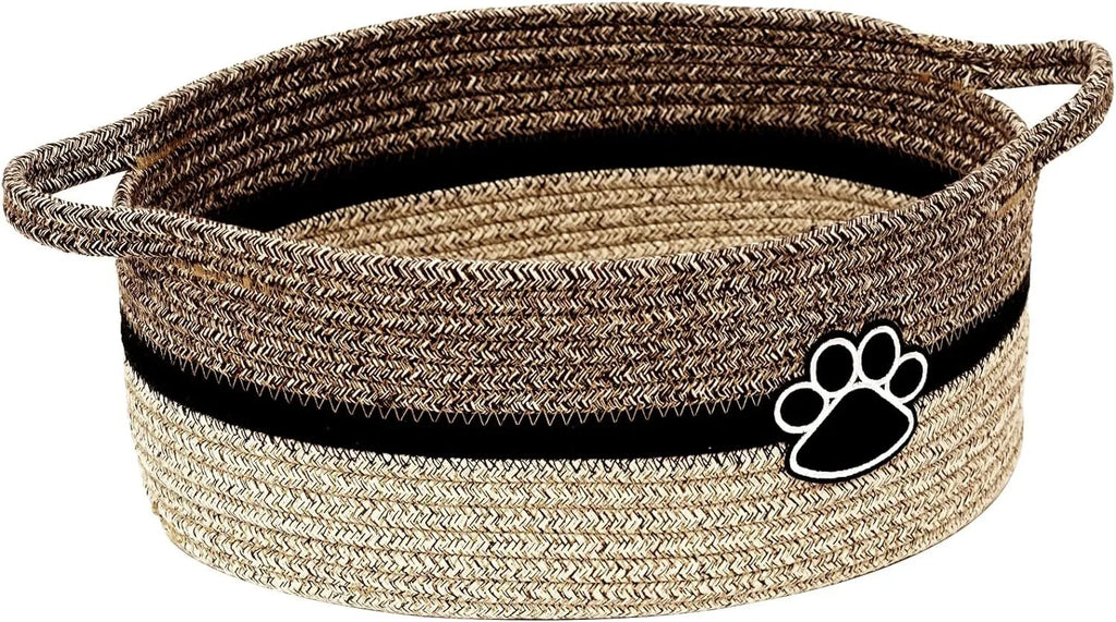Light beige handmade cotton rope woven storage basket with handle on a wooden surface.