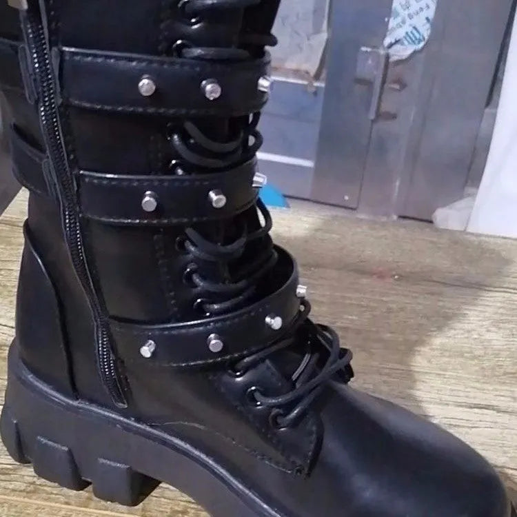 Women's black mid-calf buckle boots with side zipper and round toe on wooden floor