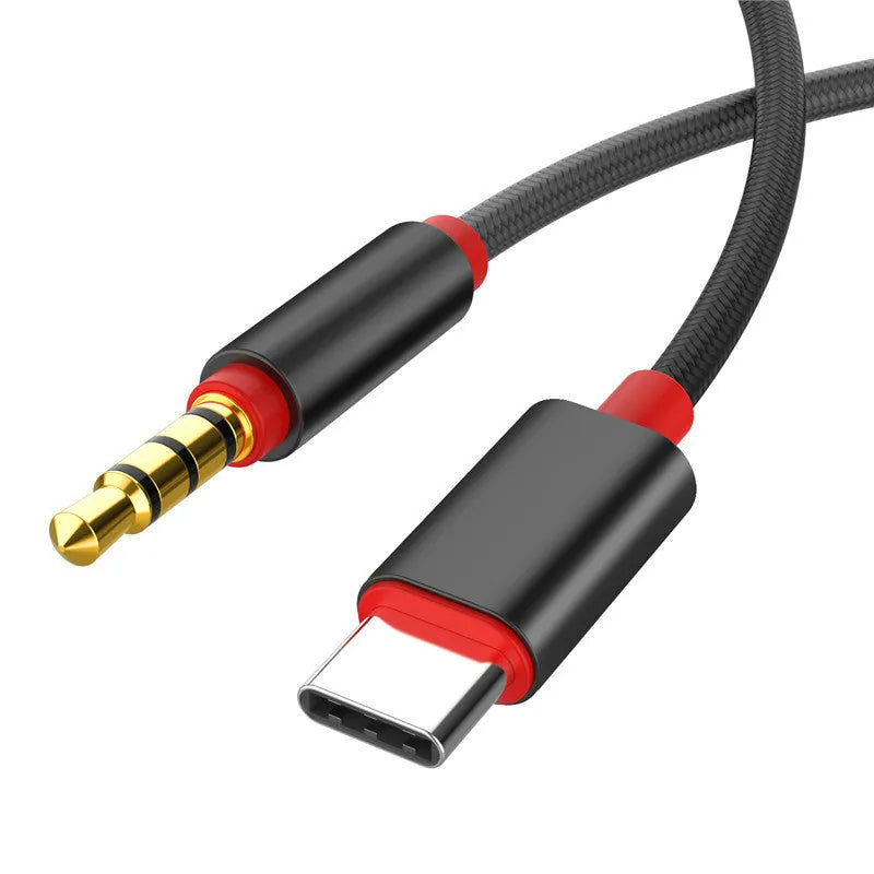 Silver 3.5mm male to male audio cable with black nylon braiding on a grey background.