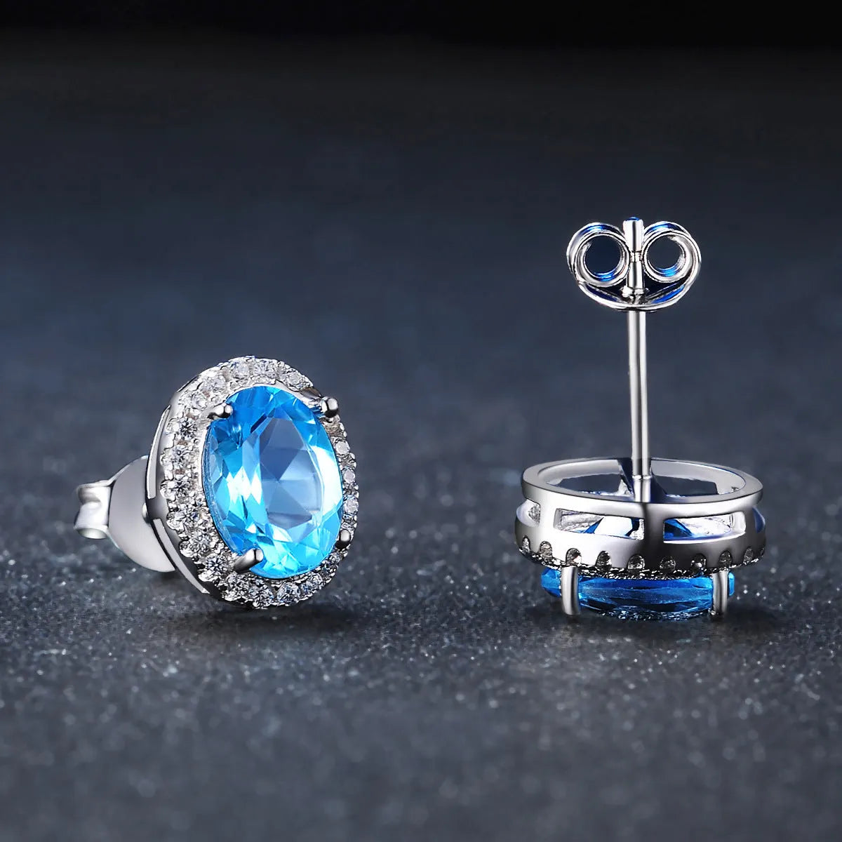 925 sterling silver jewellery set with blue topaz gems including geometric pendant necklace, earrings, ring, and bracelet.