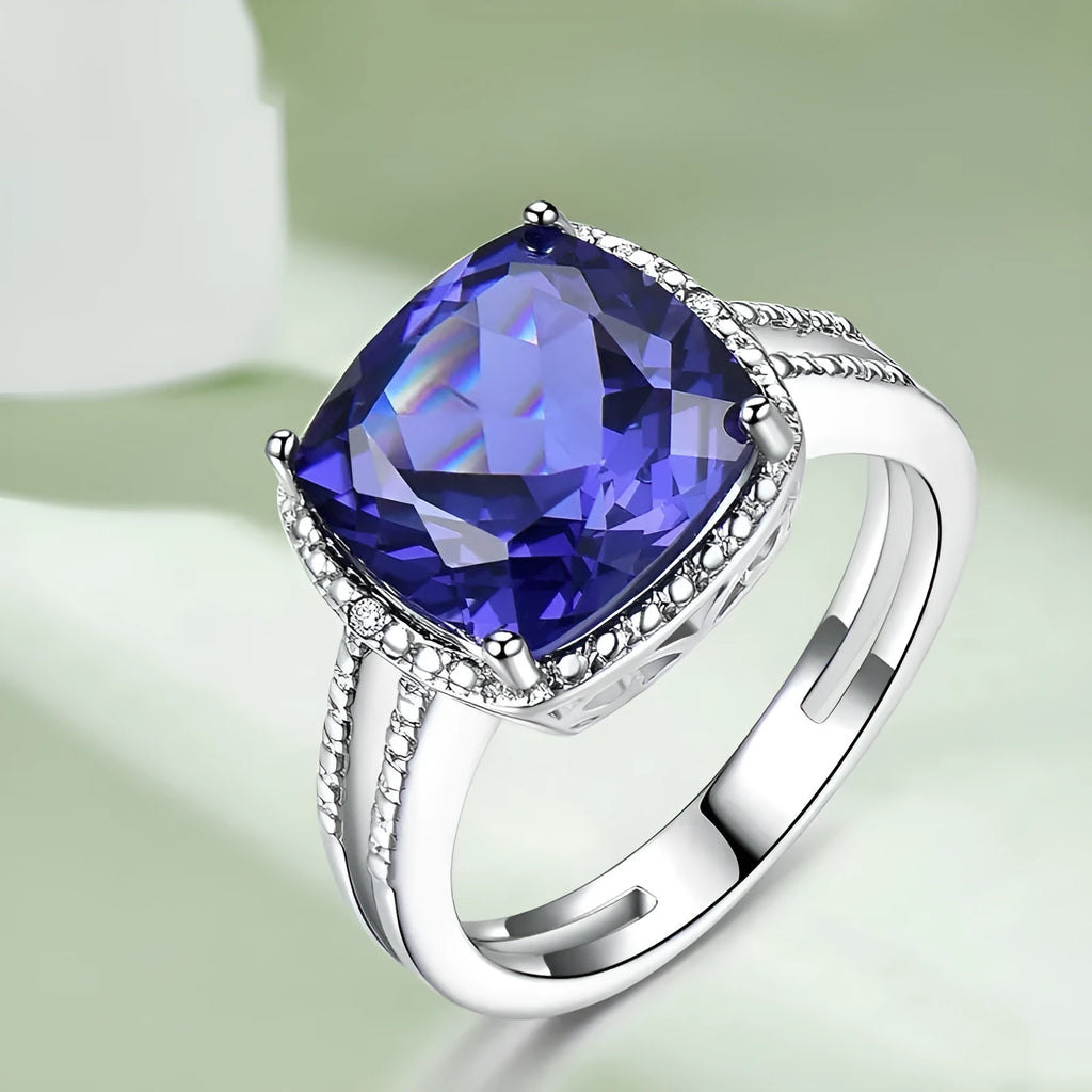 Blue tanzanite gemstone set in a sterling silver women's ring on a grey background