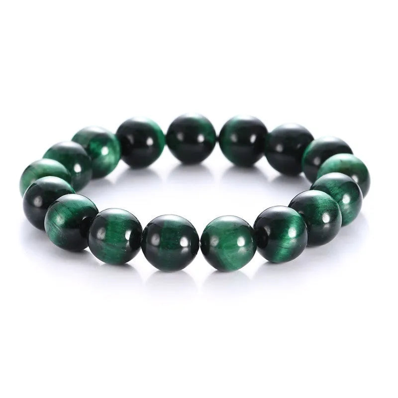 Green tiger eye stone bracelet with geometric polished beads on a wrist.