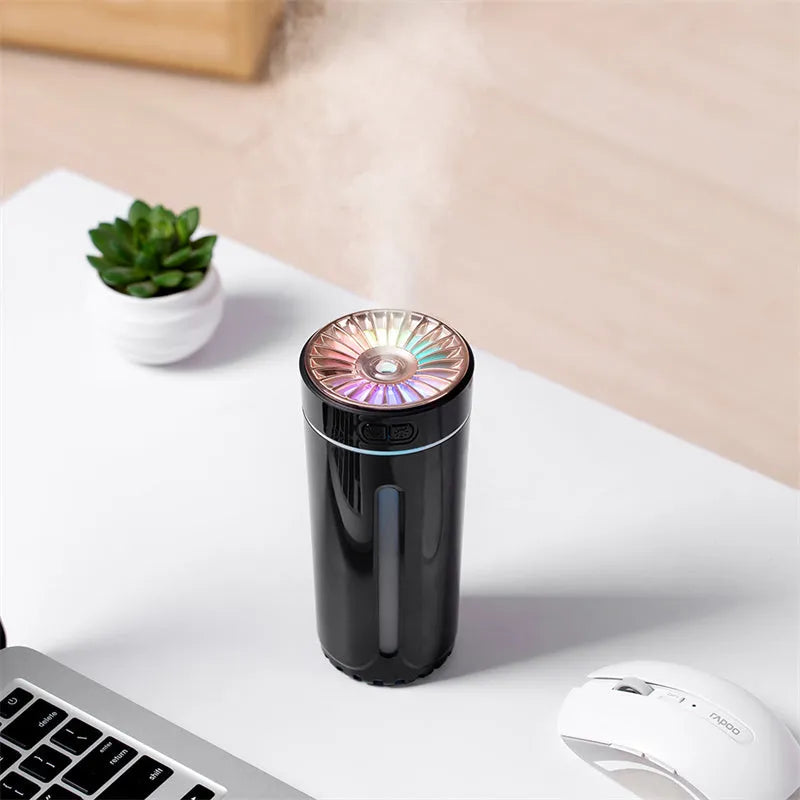 Black wireless ultrasonic humidifier with LED lights sitting in a car cup holder.