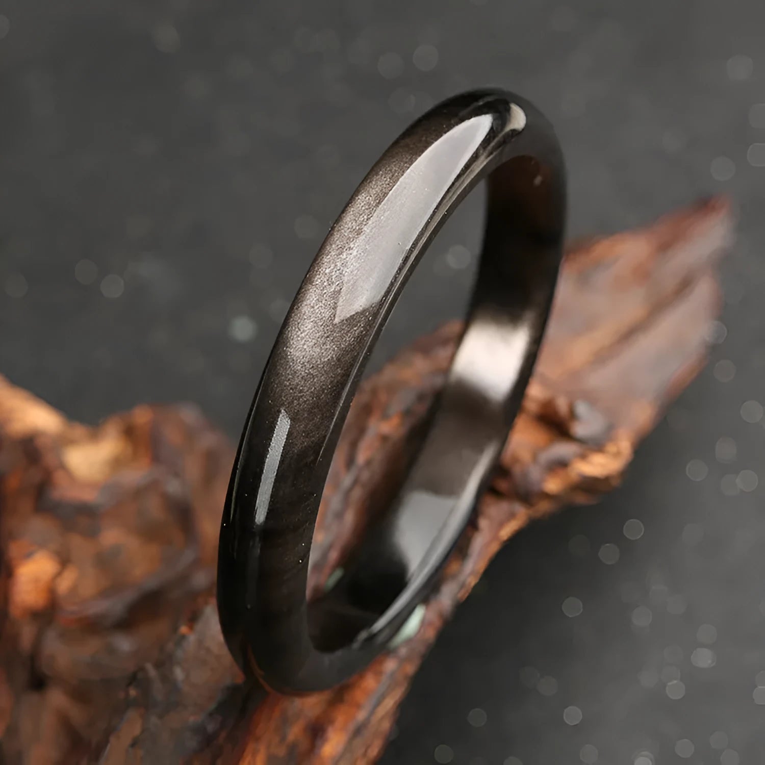 Black obsidian geometric ethnic bracelet with natural silver stone cat's eye design on a wrist.