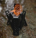 Portable hexagon alcohol camping stove showing foldable alloy construction with black finish
