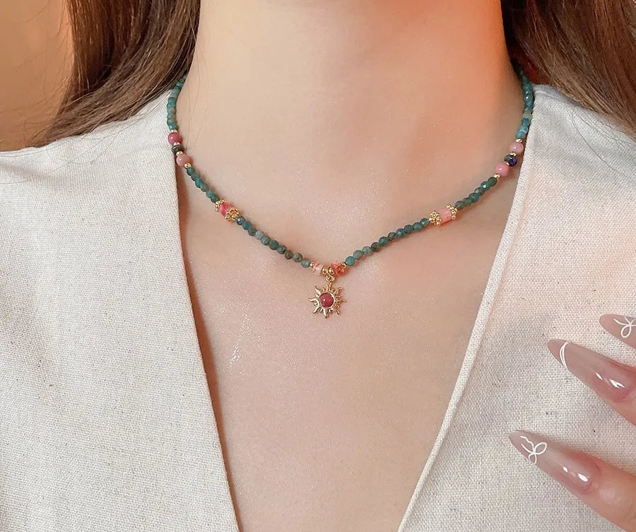 Freshwater pearl necklace with sun motif stone pendant on an adjustable clavicle chain.