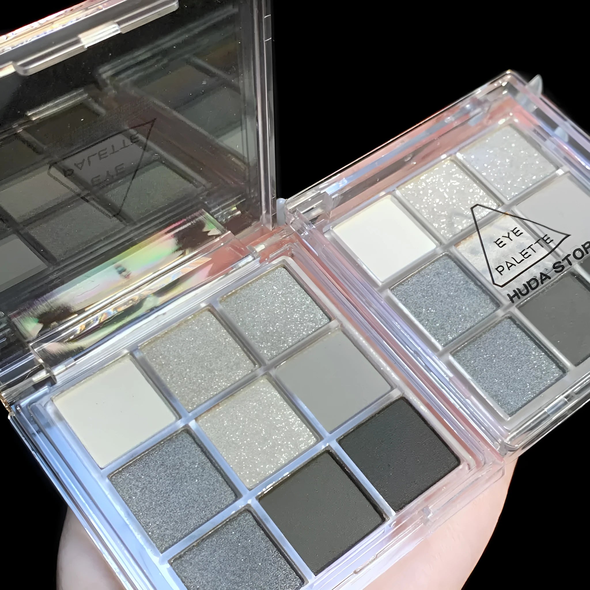 Nine-colour smoked eye shadow palette showing pressed powder shades including white, silver, black, and grey.