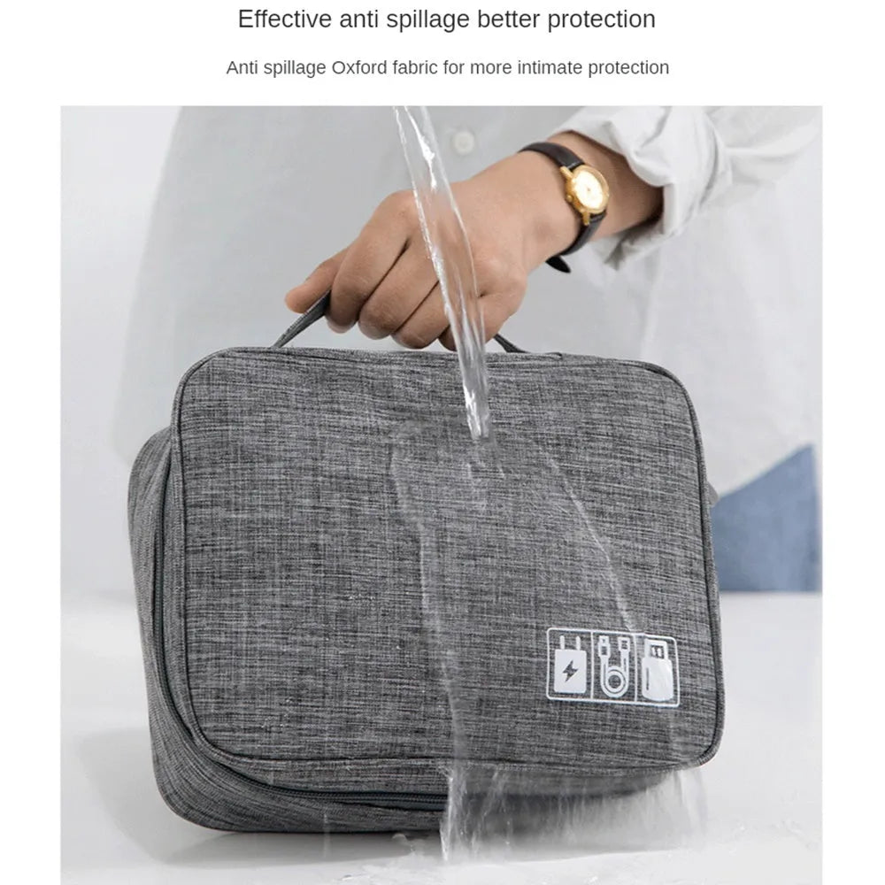 Black electronics organiser case open showing mesh pockets, elastic loops, and removable padded dividers for cable organisation