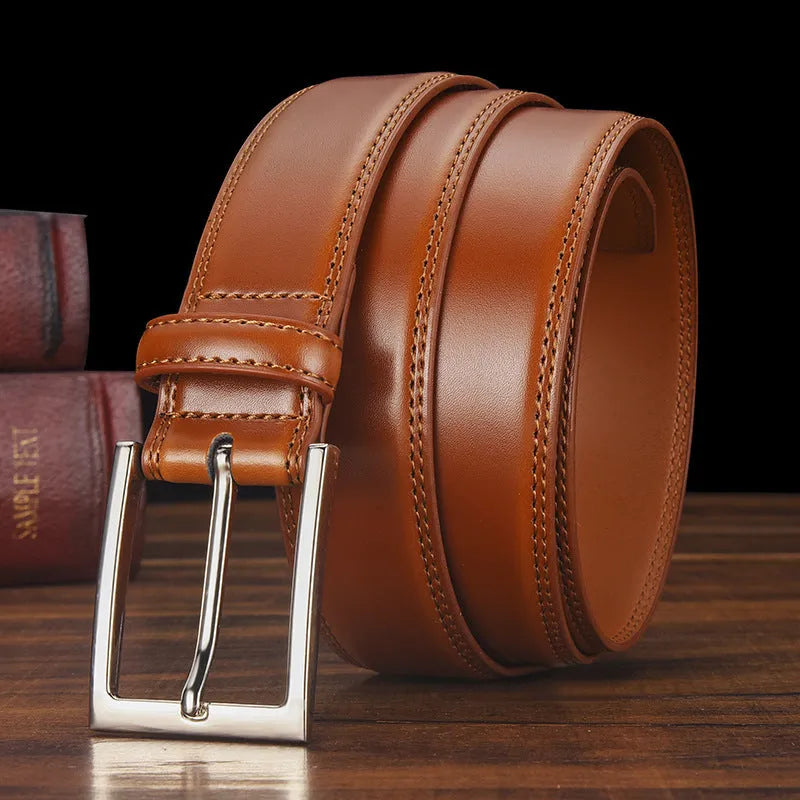 Men's black genuine leather belt with a silver alloy pin buckle fastened, showing glossy patent leather finish.
