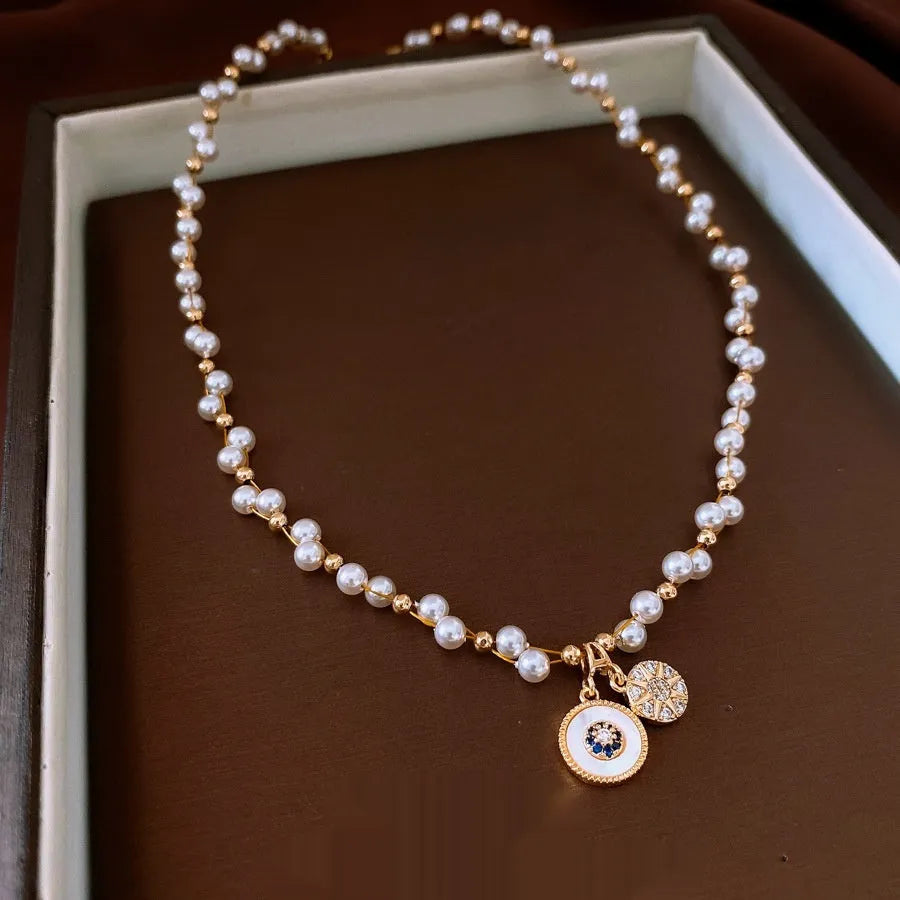 Gold electroplated pendant necklace with zircon stones and imitation pearl centre on clavicle chain