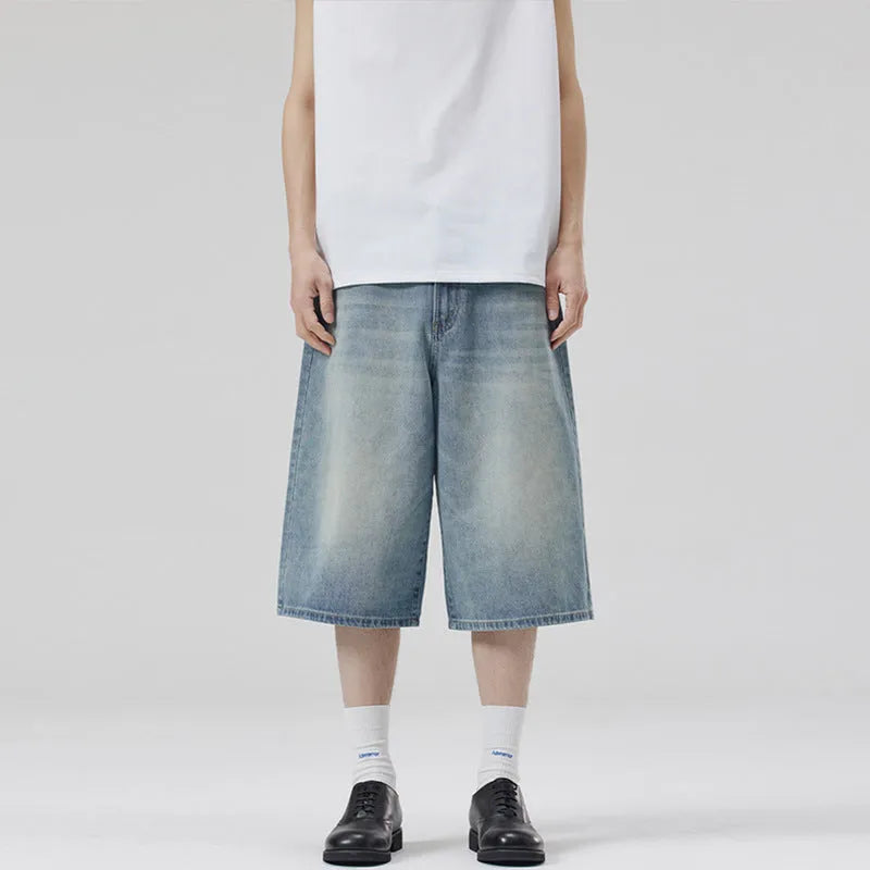Man wearing loose straight-leg cotton denim shorts in a summer casual setting.