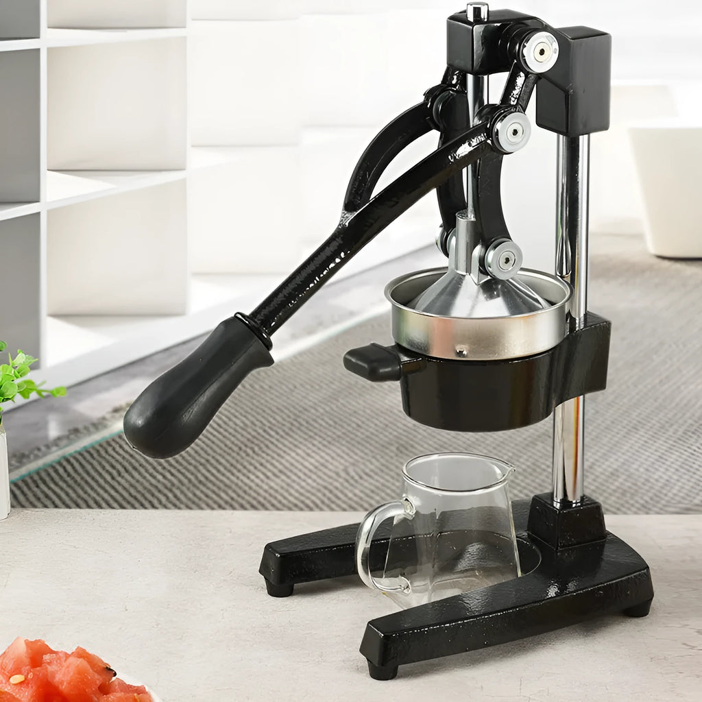 Tall black manual citrus juicer with cast iron base and stainless steel cone on a kitchen counter.