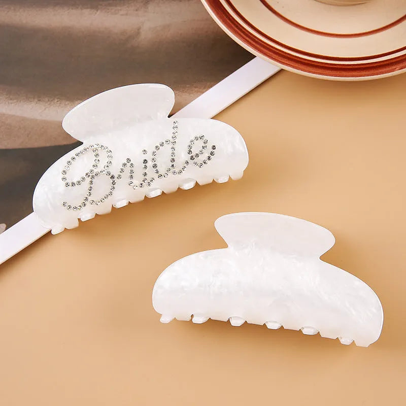 Acrylic hair barrette with diamond pattern and English letters measuring 10cm wide in pink colour