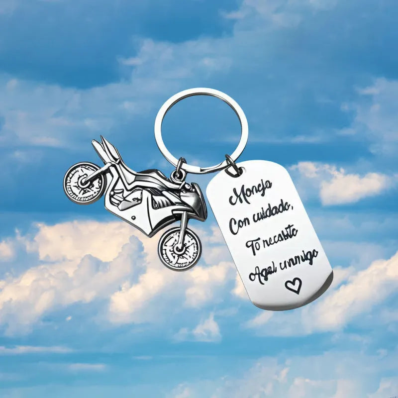 Stainless steel motorcycle-themed keychain with inspirational text alongside a flannel storage pouch.