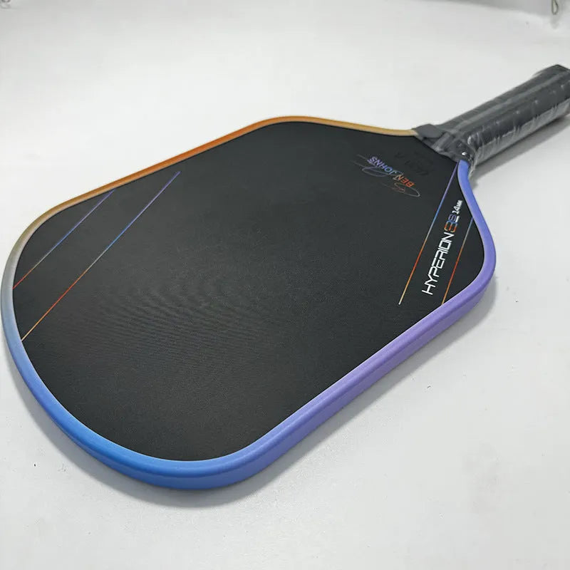 Multicolour matte-finish pickleball racket showing carbon fibre texture and honeycomb core construction.