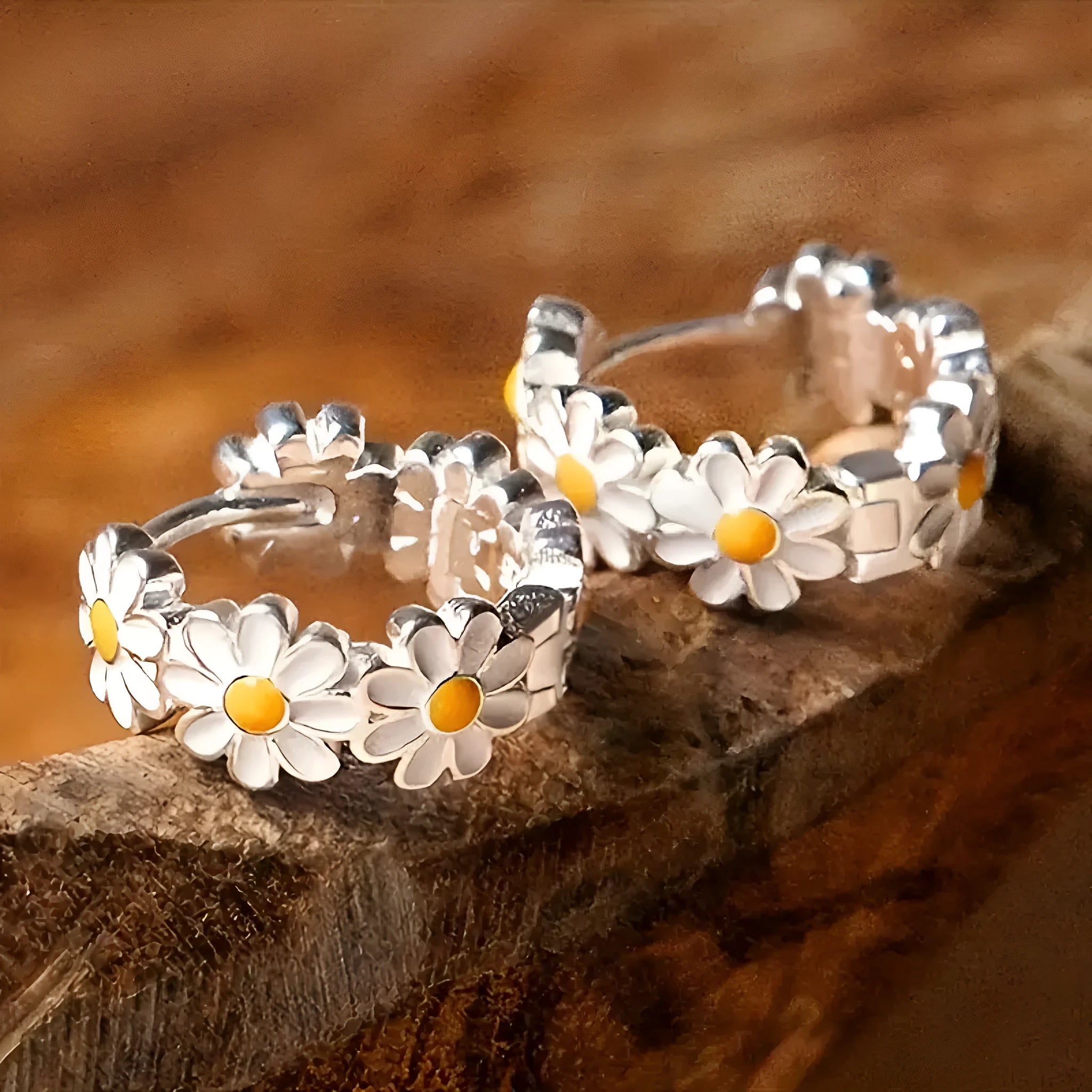A pair of white daisy flower ring earrings with inlaid gems, shown on a plain background.
