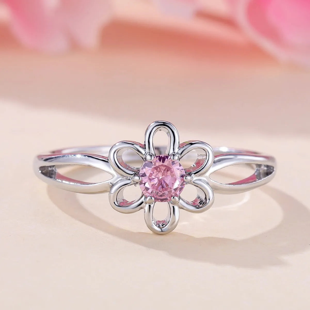 Lady's copper flower hollowed ring with electroplated finish in white gold powder colour on white background
