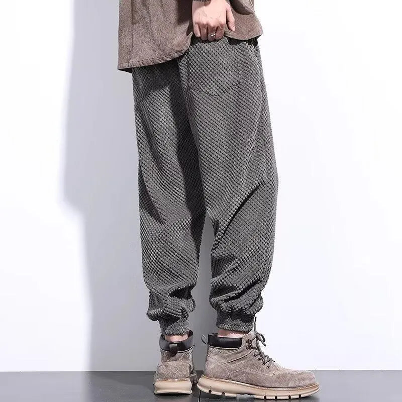 Men's grey straight-leg sweatpants with ankle ties laid flat.