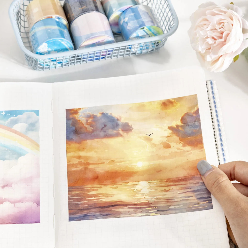 Roll of Japanese paper decorative washi tape with sky theme designs, showing colourful clouds, sunny day, and twilight patterns.
