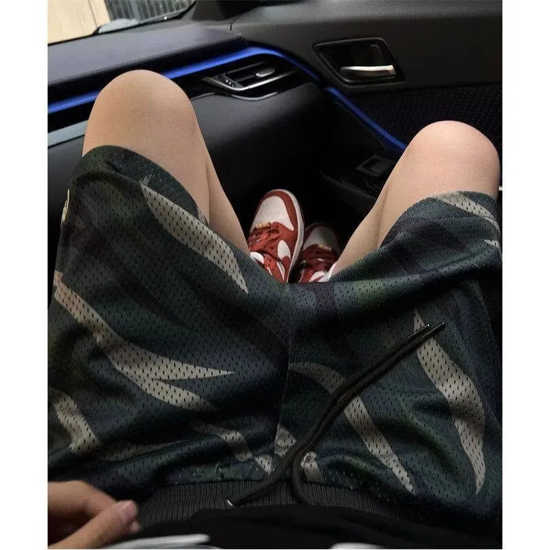 Men's camouflage coloured straight-leg mesh shorts made from a cotton blend fabric.