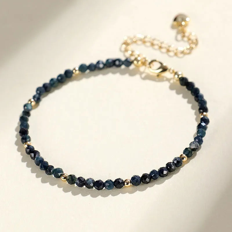Close-up of a blue tourmaline bracelet with 3mm cut beads and spacer beads.
